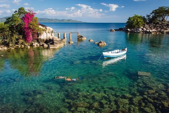 Visitor looking through binoculars at Lake Malawi, taking in the scenery